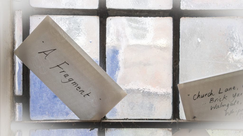 Envelope with 'fragment' written on it, on a window.